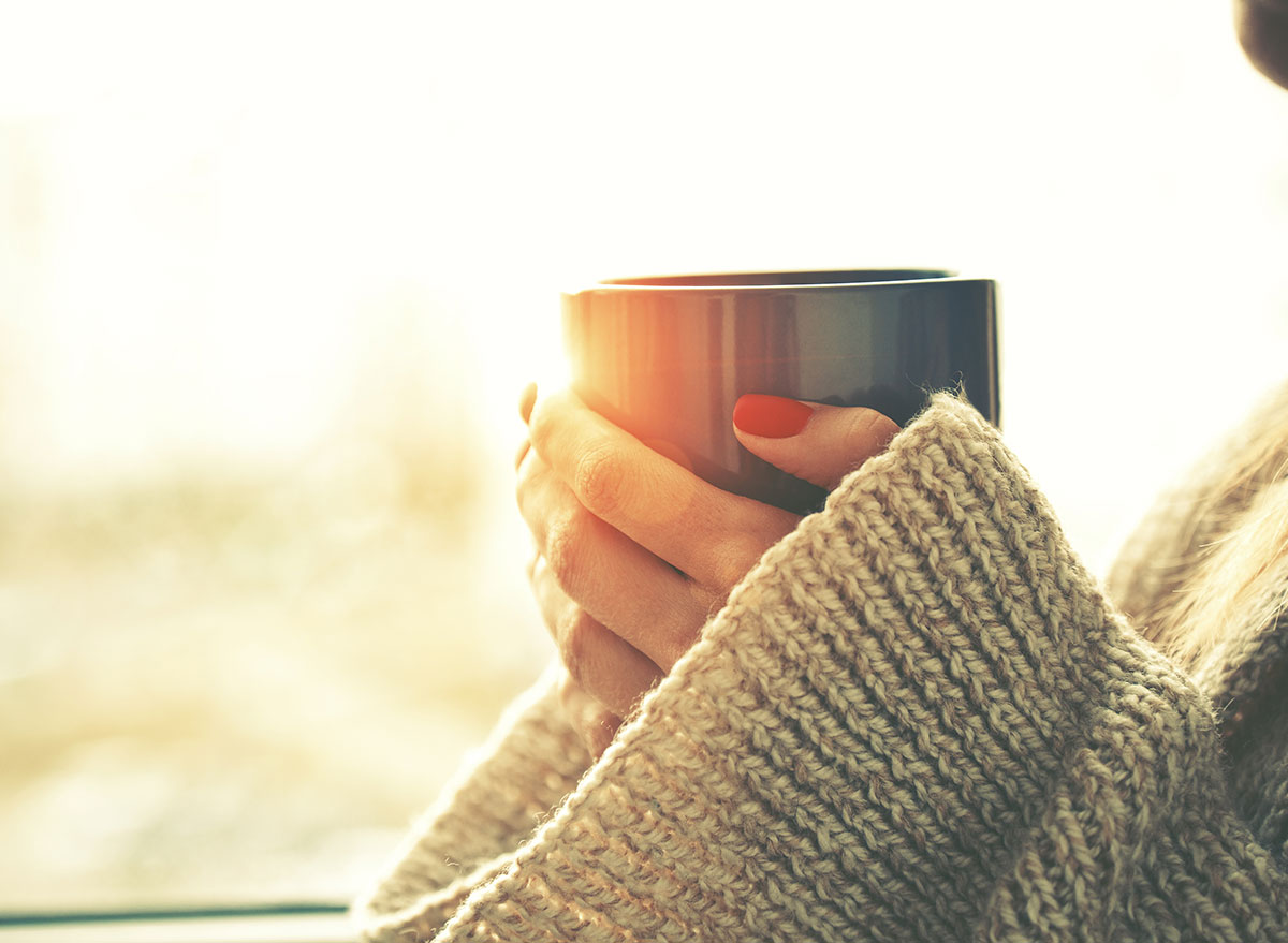 عکس یک فنجان قهوه در دستان یک زن