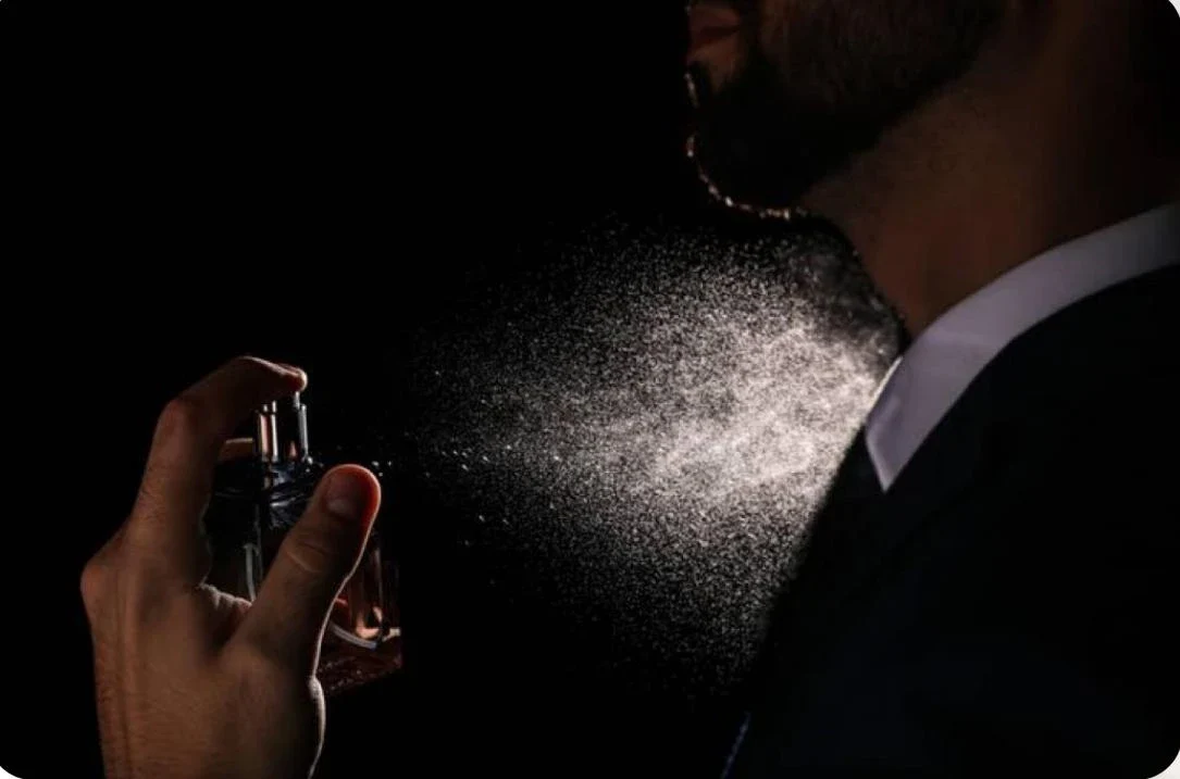 نحوه استفاده از عطر مردانه- مردی در حال زدن عطر روی گردن